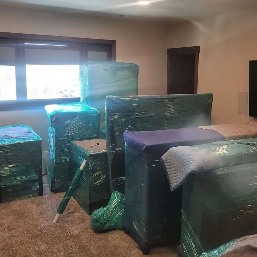 A room packed with furniture and boxes, facilitated by professional moving helpers from a long distance moving company.
