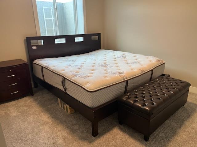 A local moving company in Casper Wyoming providing moving services for a bed and mattress with the addition of a footstool in a room.