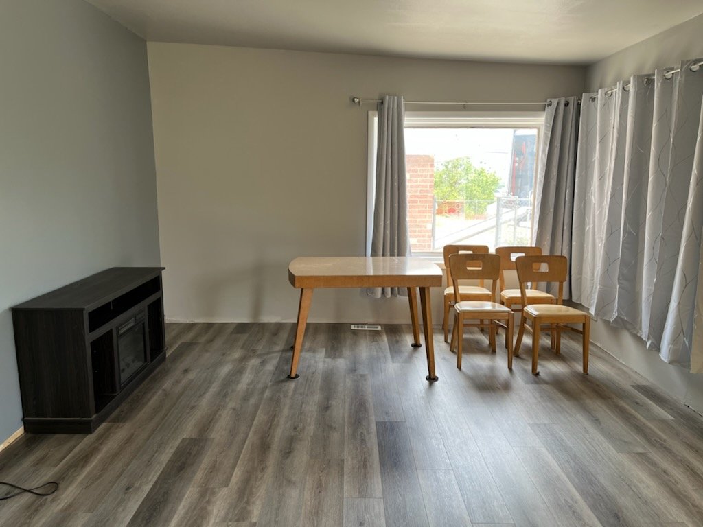 Long distance moving company offering moving services sets up an empty living room with a table and chairs.