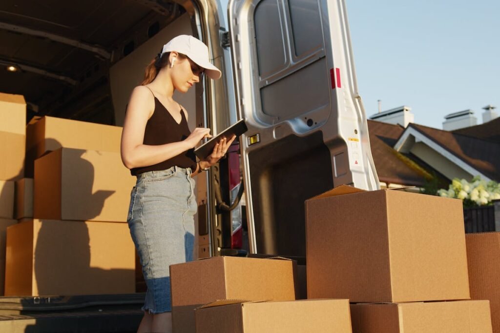 A woman inspecting boxes in a moving van while referring to "From Start to Finish: A Comprehensive Guide to Hiring Professional Movers".