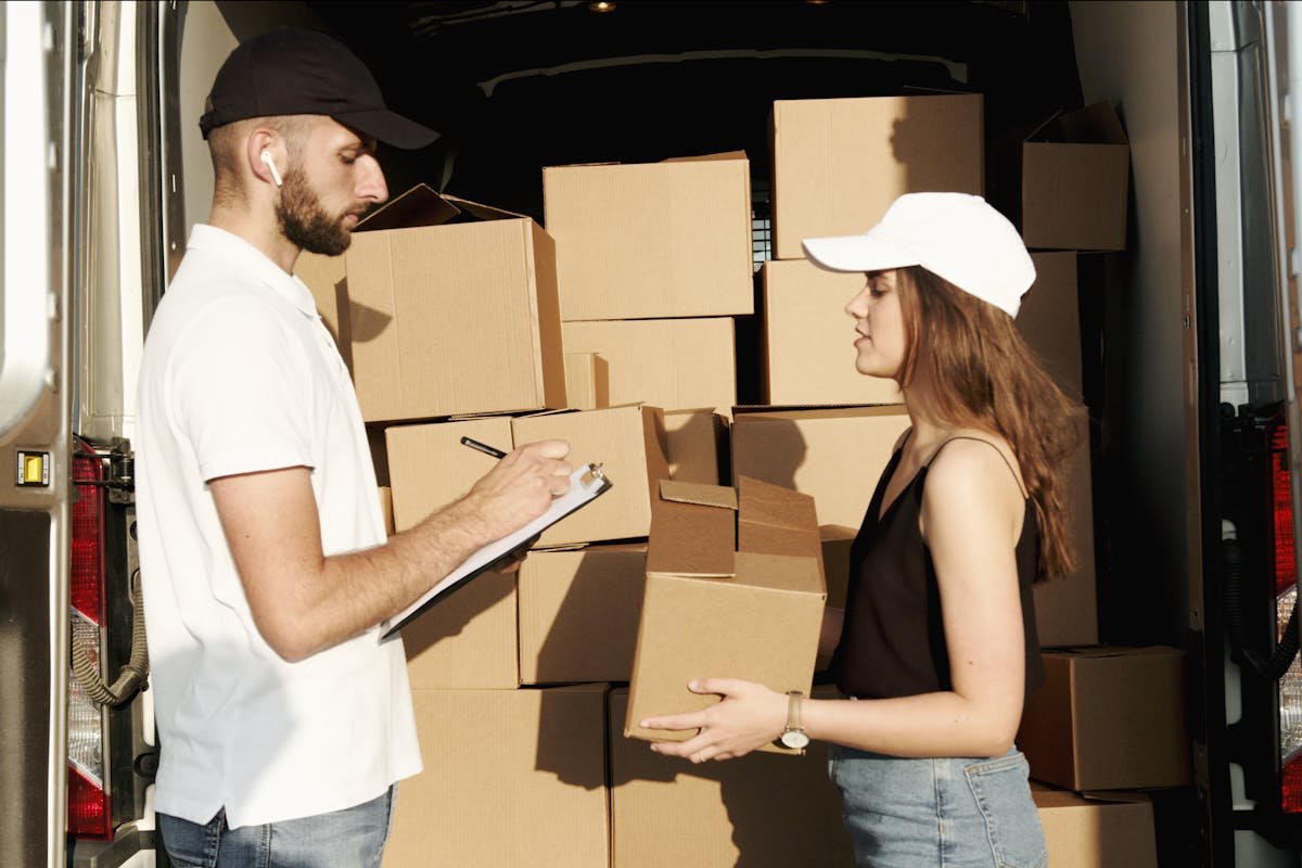 A man and woman standing in the back of a moving truck, illustrating Tips for a Stress-Free Transition.